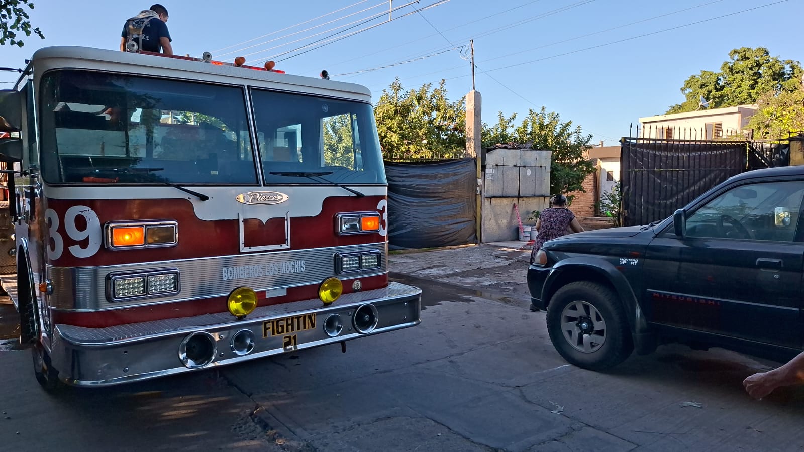 Unidad de Bomberos junto a una casa