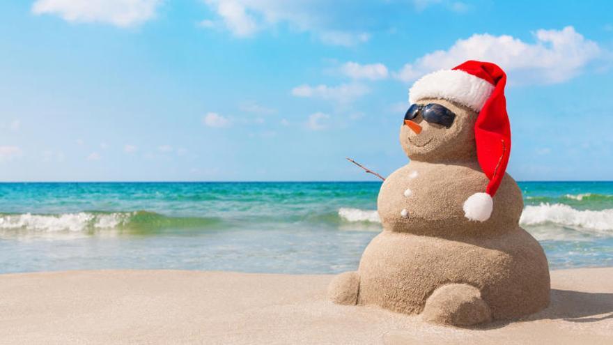 Mono de arena con gorro navideño en la playa