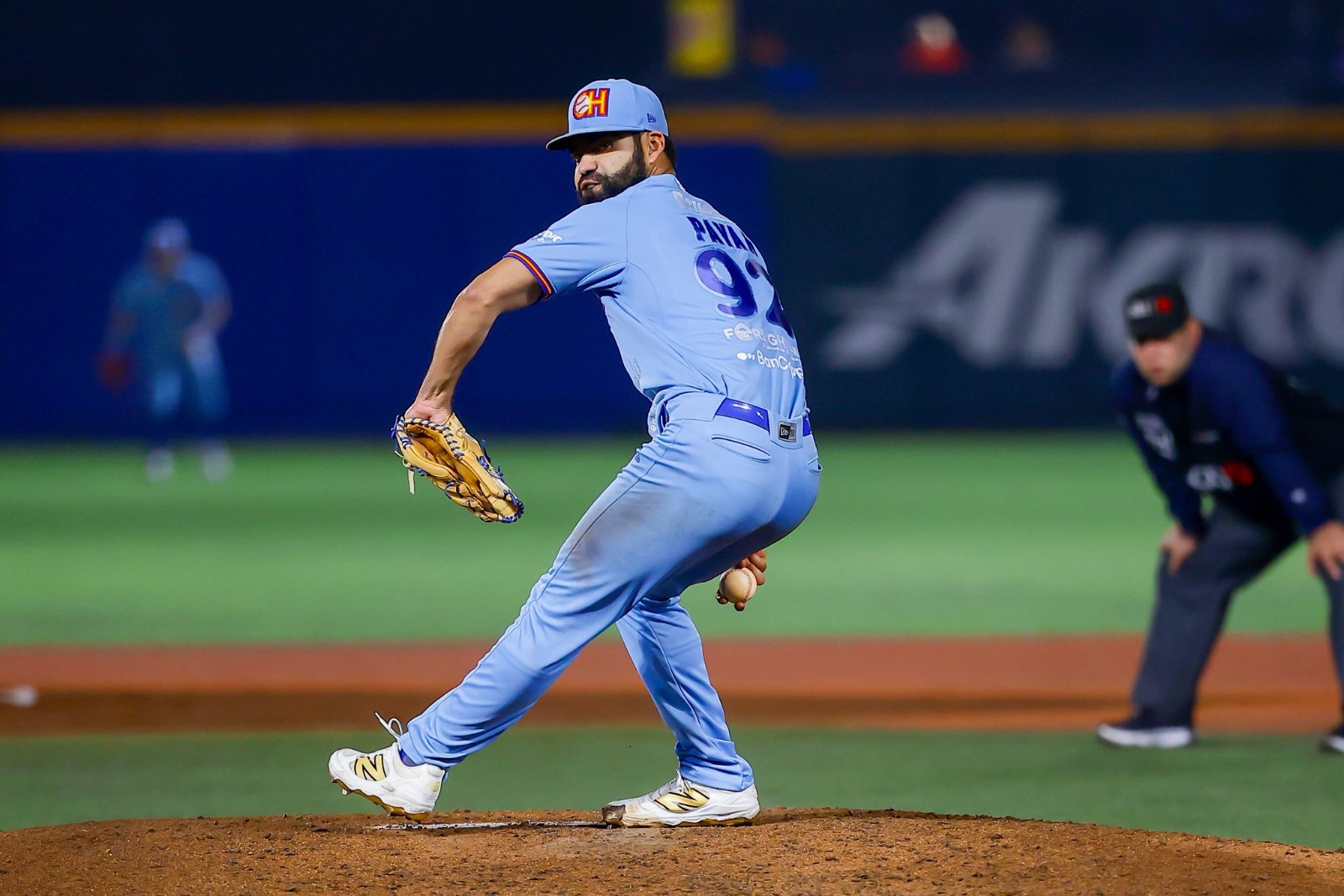 Jugador de beisbol lanzando una pelota en un estadio