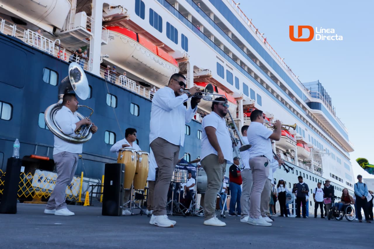Crucero Zaadam de fondo habiendo llegado al puerto de Topolobampo y debajo una banda tocando y cantando para recibir a los turistas.