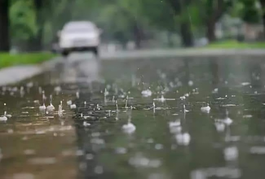 Gotas de lluvia sobre pavimento mojado en primer plano.