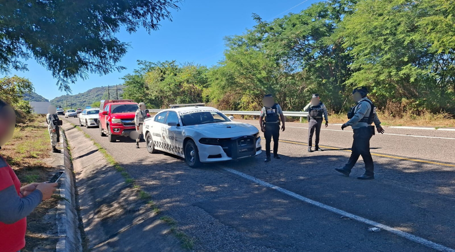 Elementos de la guardia nacional estacionados en la carretera, revisando el perímetro