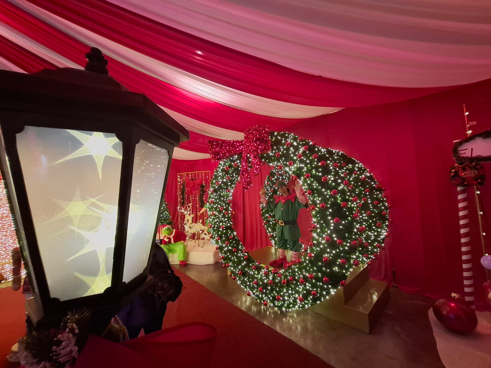Hombre vestido de duende dentro de coronas navideñas