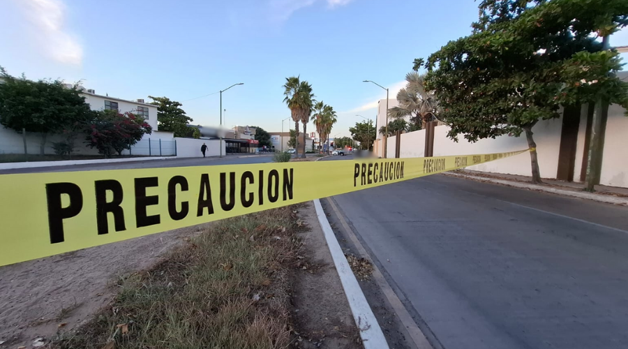Cinta amarilla de precaución con una unidad de policía de fondo