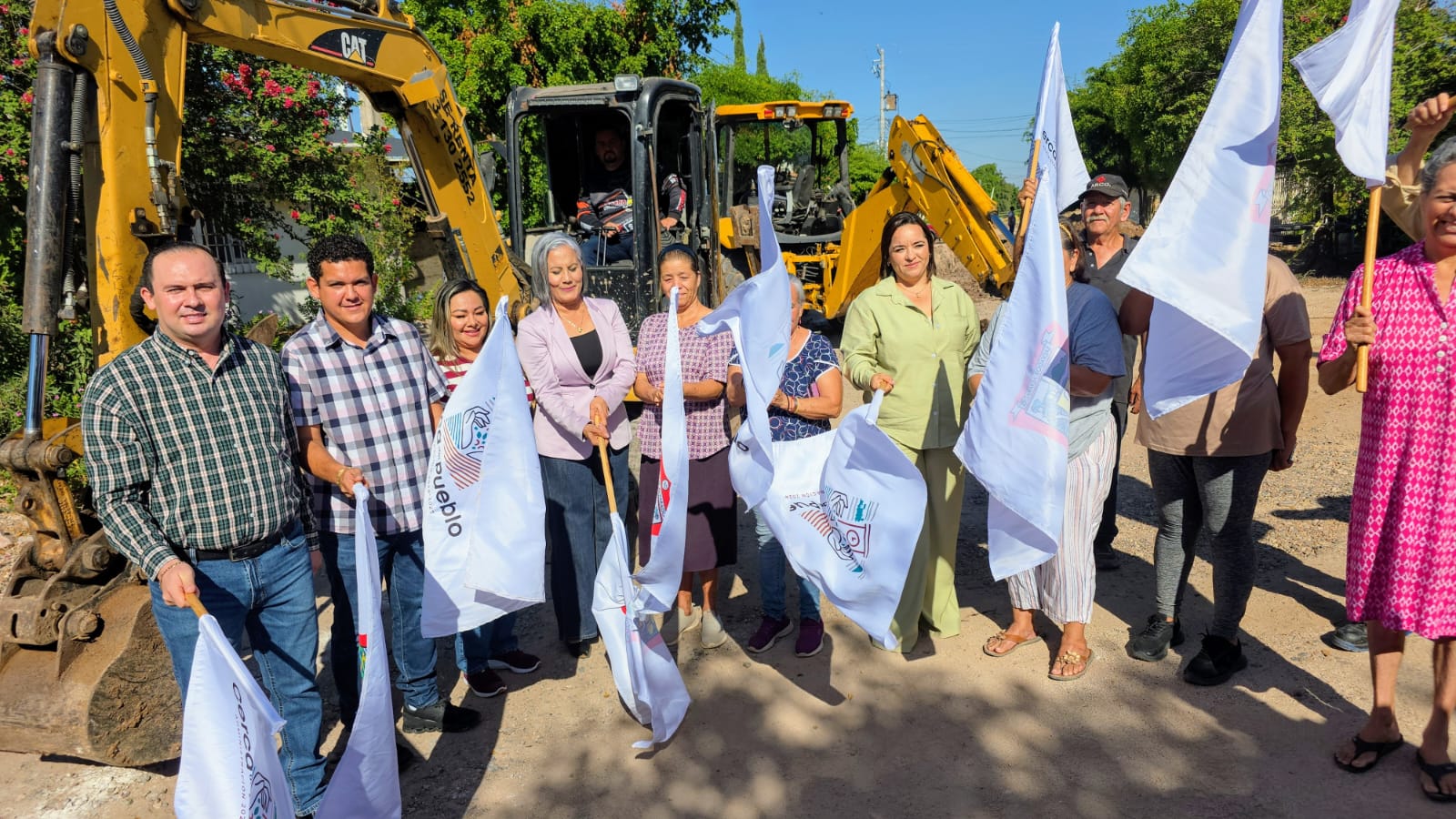Alcaldesa de Salvador Alvarado con bandera de obras y maquinaria de construcción de fondo