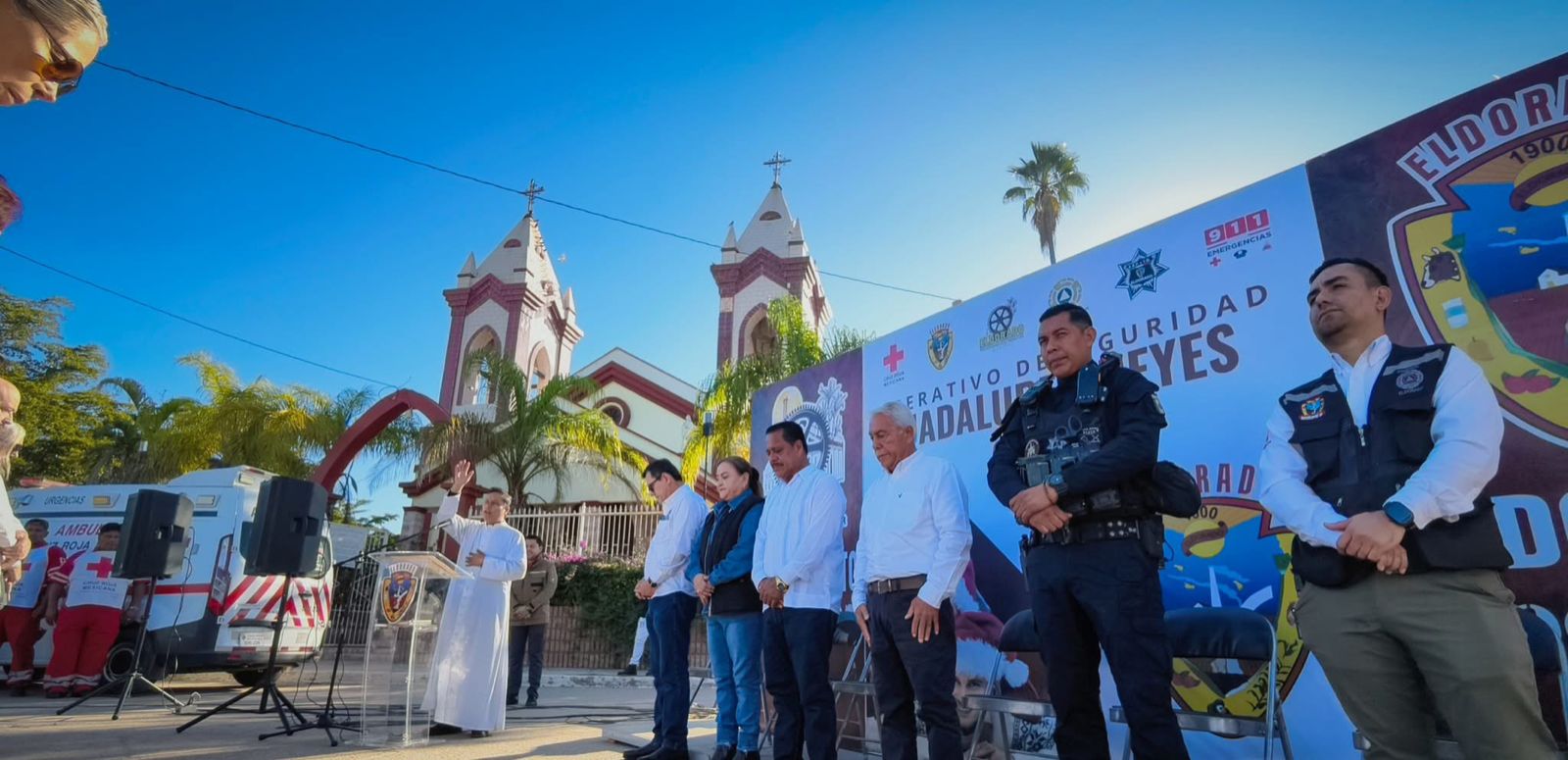 Personas arriba de una tarima frente a una catedral durante una ceremonia