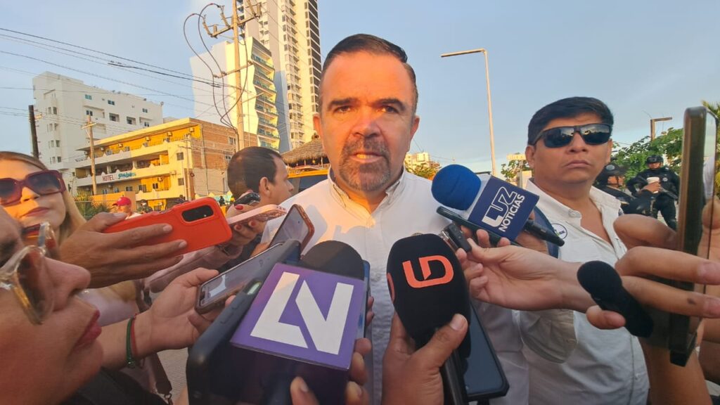 Persona hablando frente a muchos micrófonos