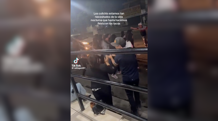 Personas bailando afuera de una taquería