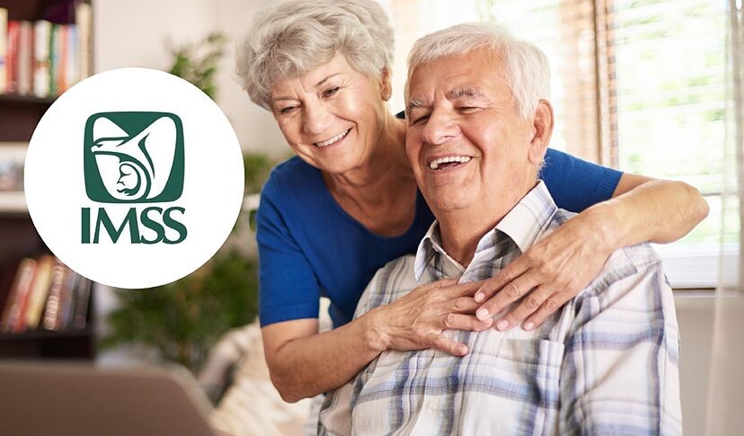 Adultos mayores sonriendo frente a una laptop con el logo del IMSS