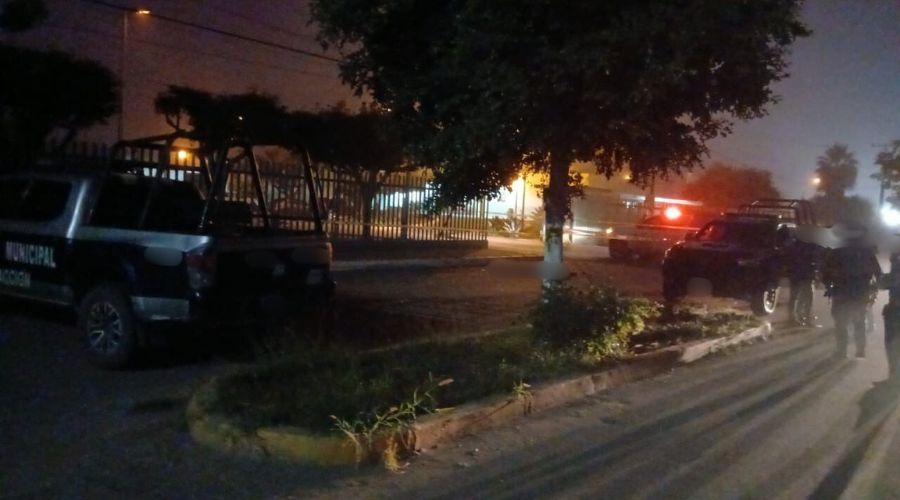 Patrullas en una calle con cinta amarilla asegurnado la zona donde hay un cuerpo tirado