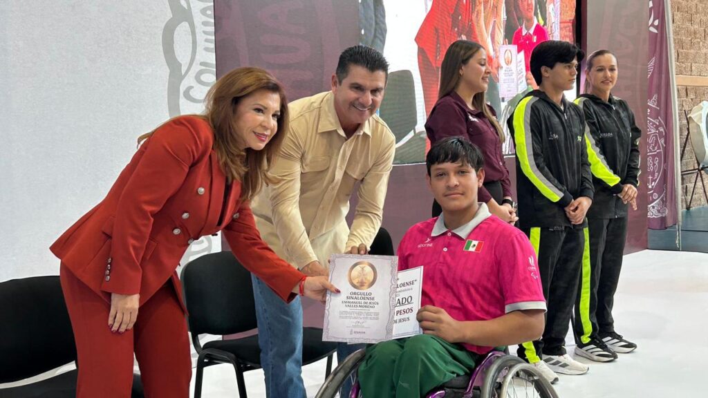 PErsonas entregando reconocimiento a un atleta en silla de ruedas
