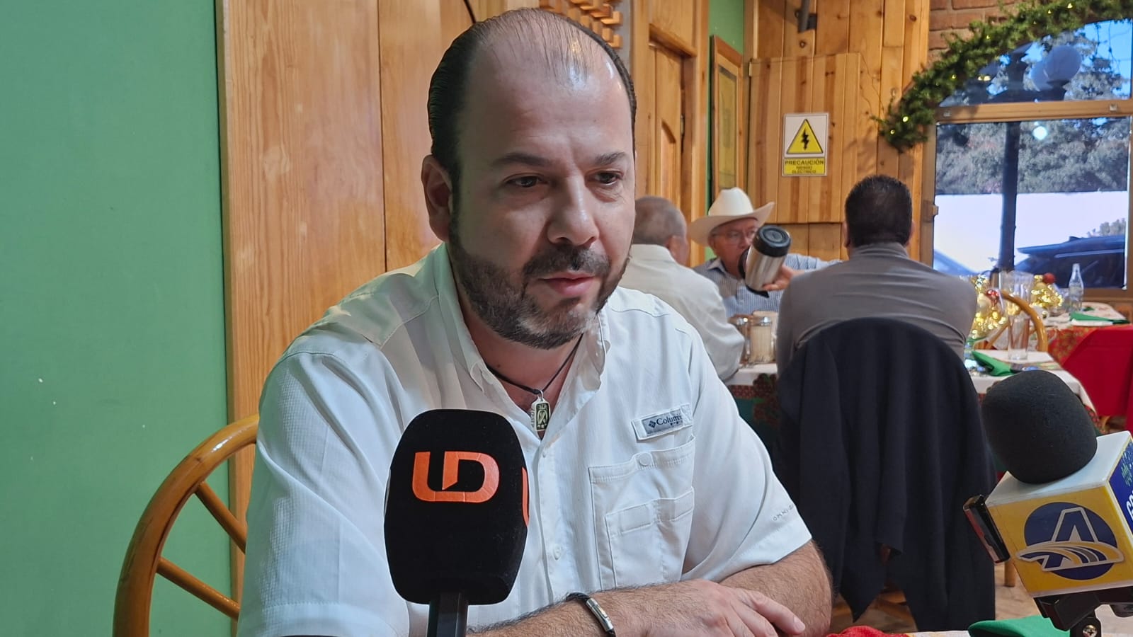 Erick Mena Sandoval junto a un micrófono de Línea Directa sentado