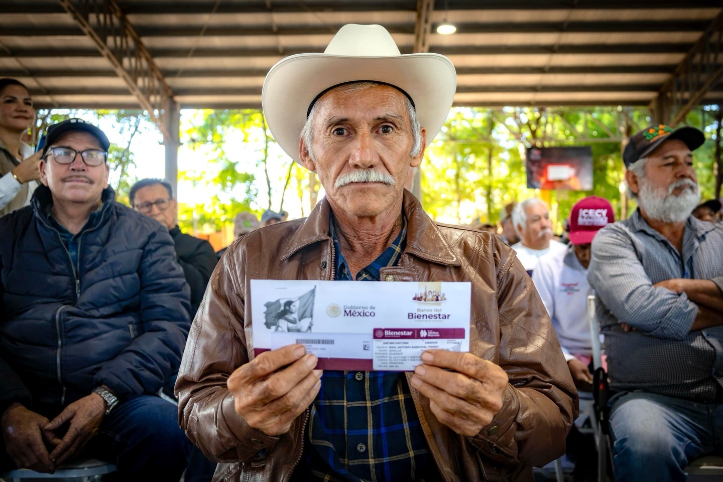 Persona sosteniendo un sobre del Bienestar