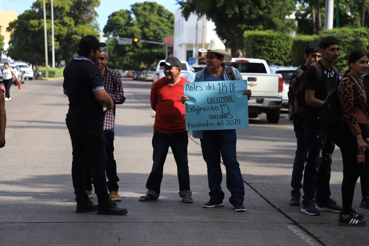 Comuneros en la calle tapando accesos al congreso del estado, sosteniendo pancartas en forma de protesta