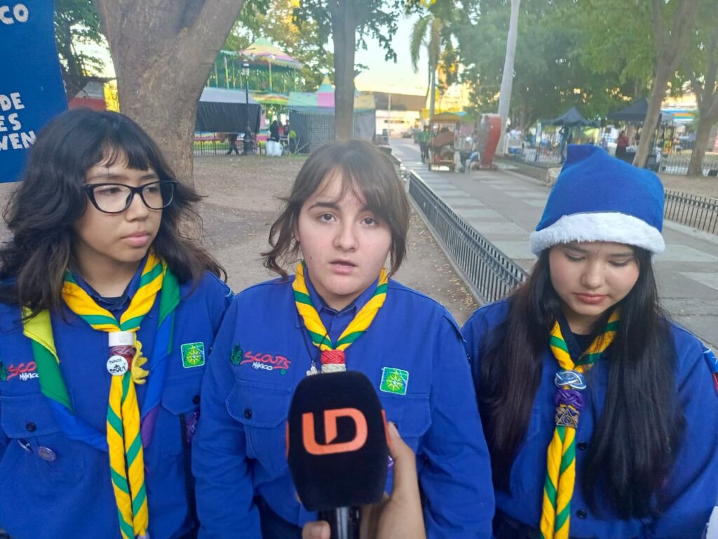 Tres scouts de Los Mochis con camisa color azul y un micrófono de Línea Directa