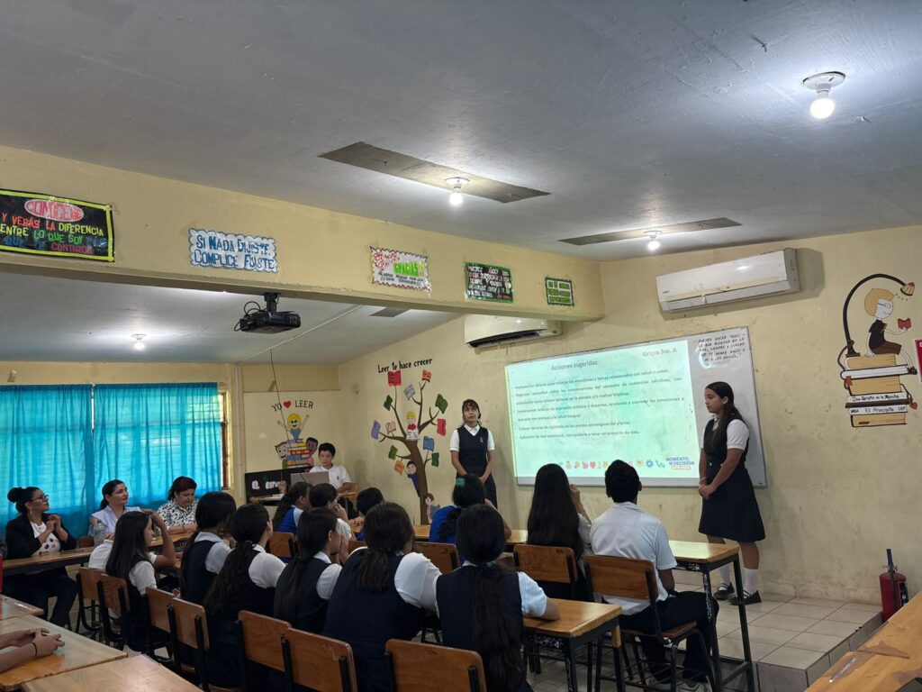 Estudiantes sentados junto a una proyección