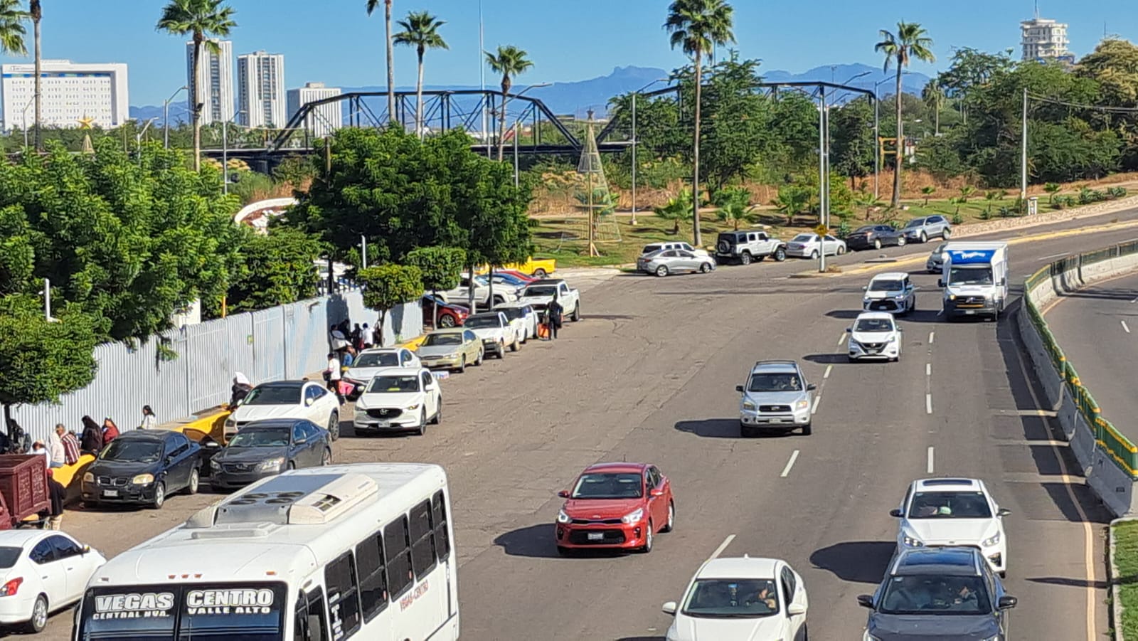Calle con automóviles privados y públicos transitando