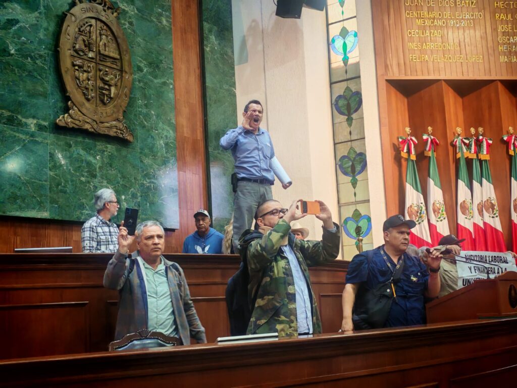 Persona gritando arriba de la mesa de la sala del Congreso de Sinaloa