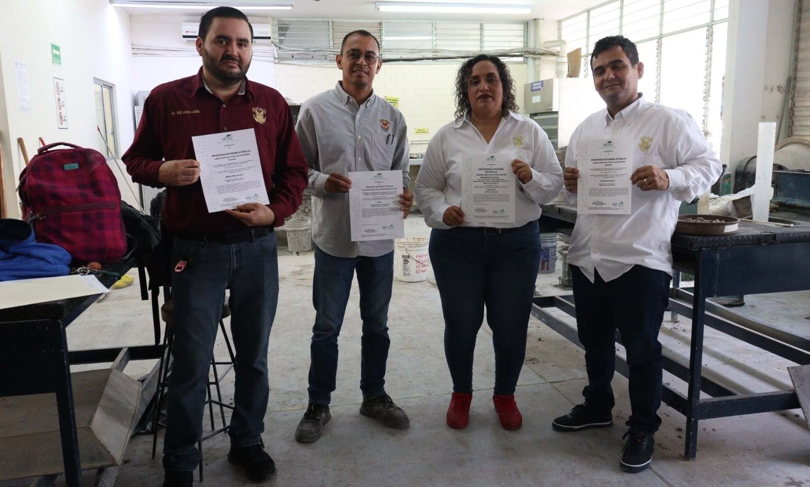 Personas en un laboratorio sosteniendo documentos en sus manos