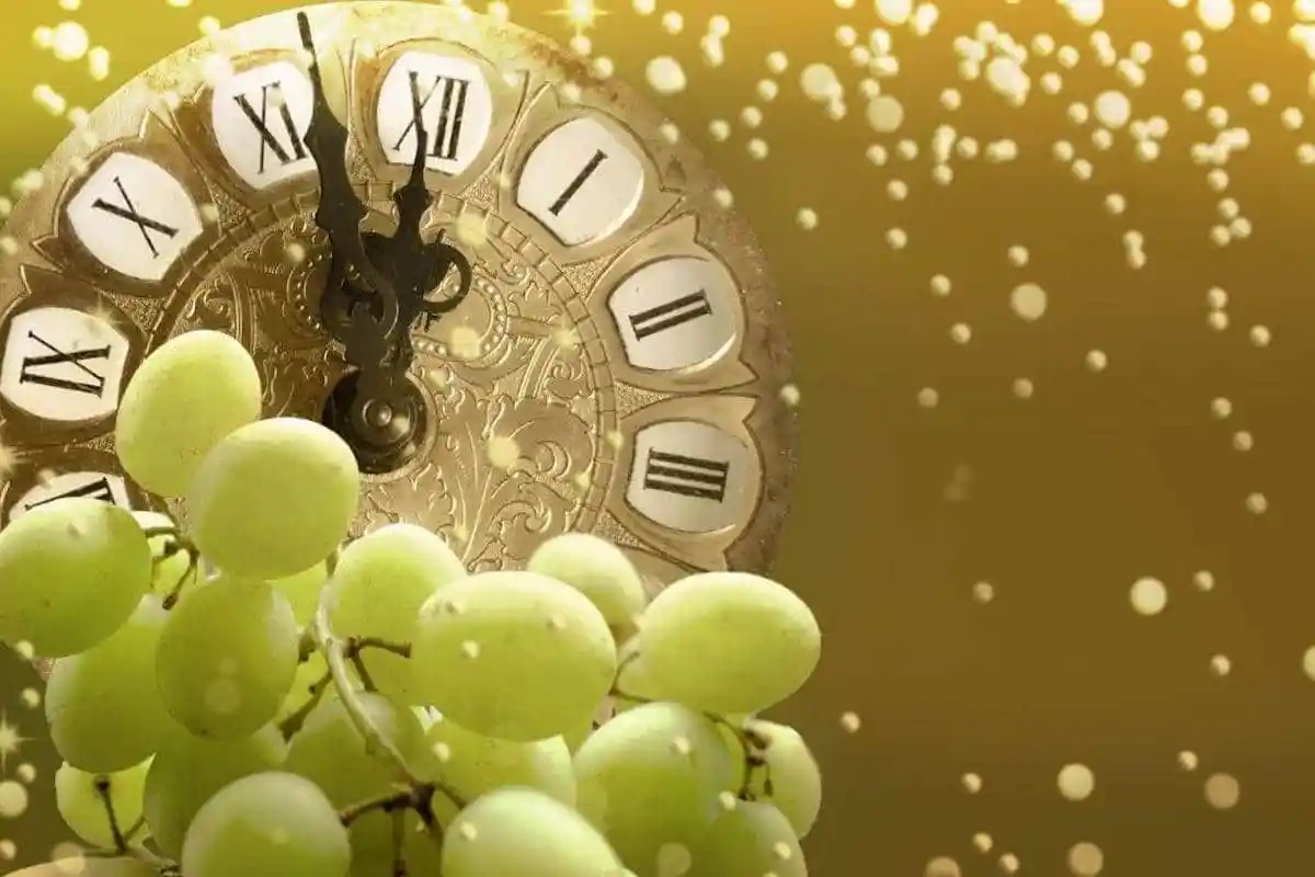 Uvas verdes y atrás un reloj