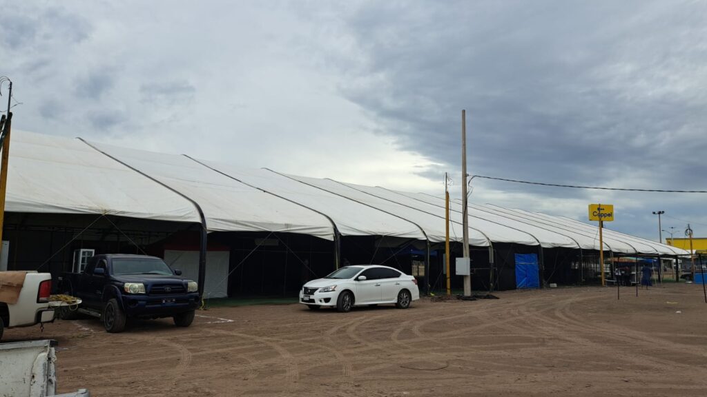 Carros y carpa en terreno de Los Mochis