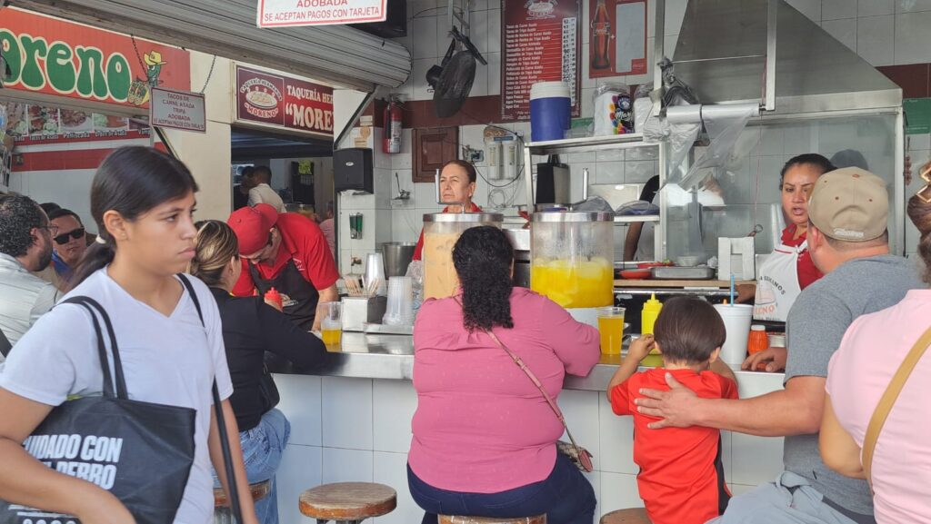Personas comiendo en local de mercado de Culiacán