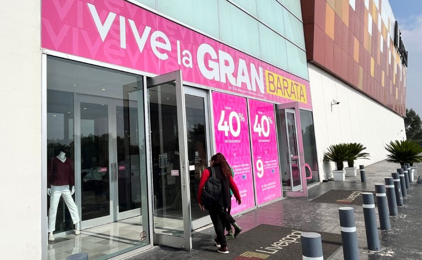 Una mujer entra a una tienda de Liverpool que promociona la gran barata