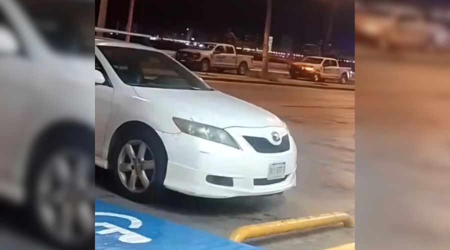 Vehículo color blanco en un estacionamiento, al fondo se observan unidades de corporaciones policiacas en Mazatlán