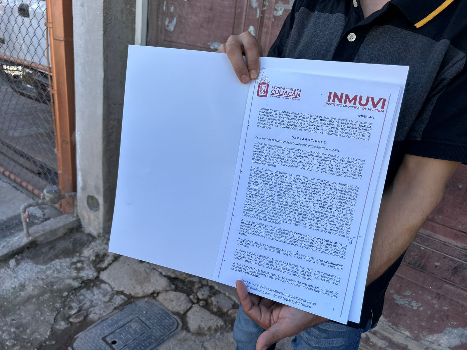 Documento de escrituras siendo sostenidas por una persona