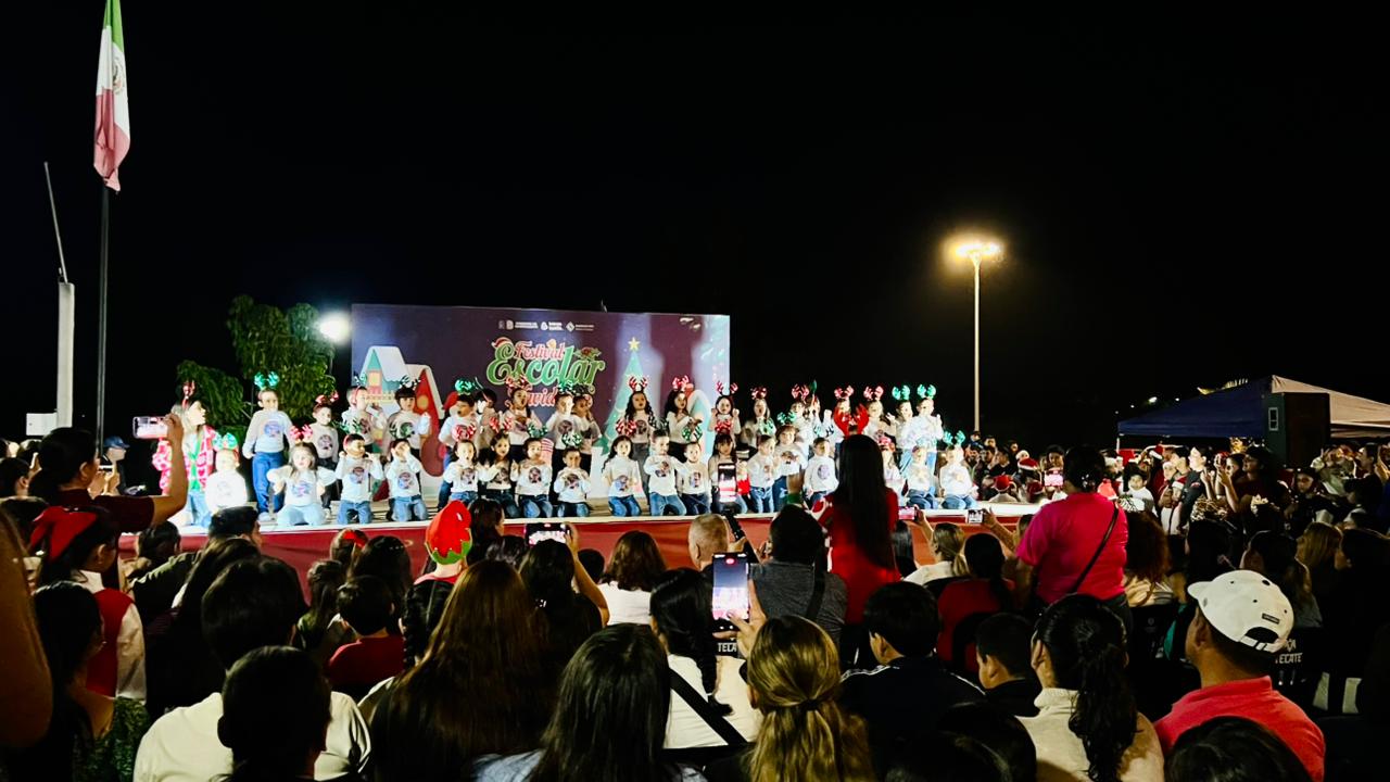 Niños en un escenario y un público viéndolos