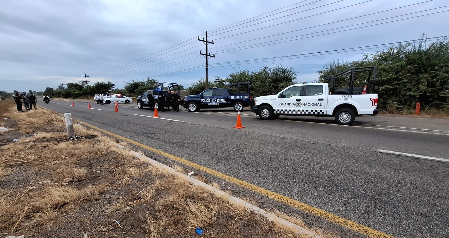 Unidades policiacas en una carretera bloqueando el paso y delimitando la zona en la que encontraron a una persona sin vida