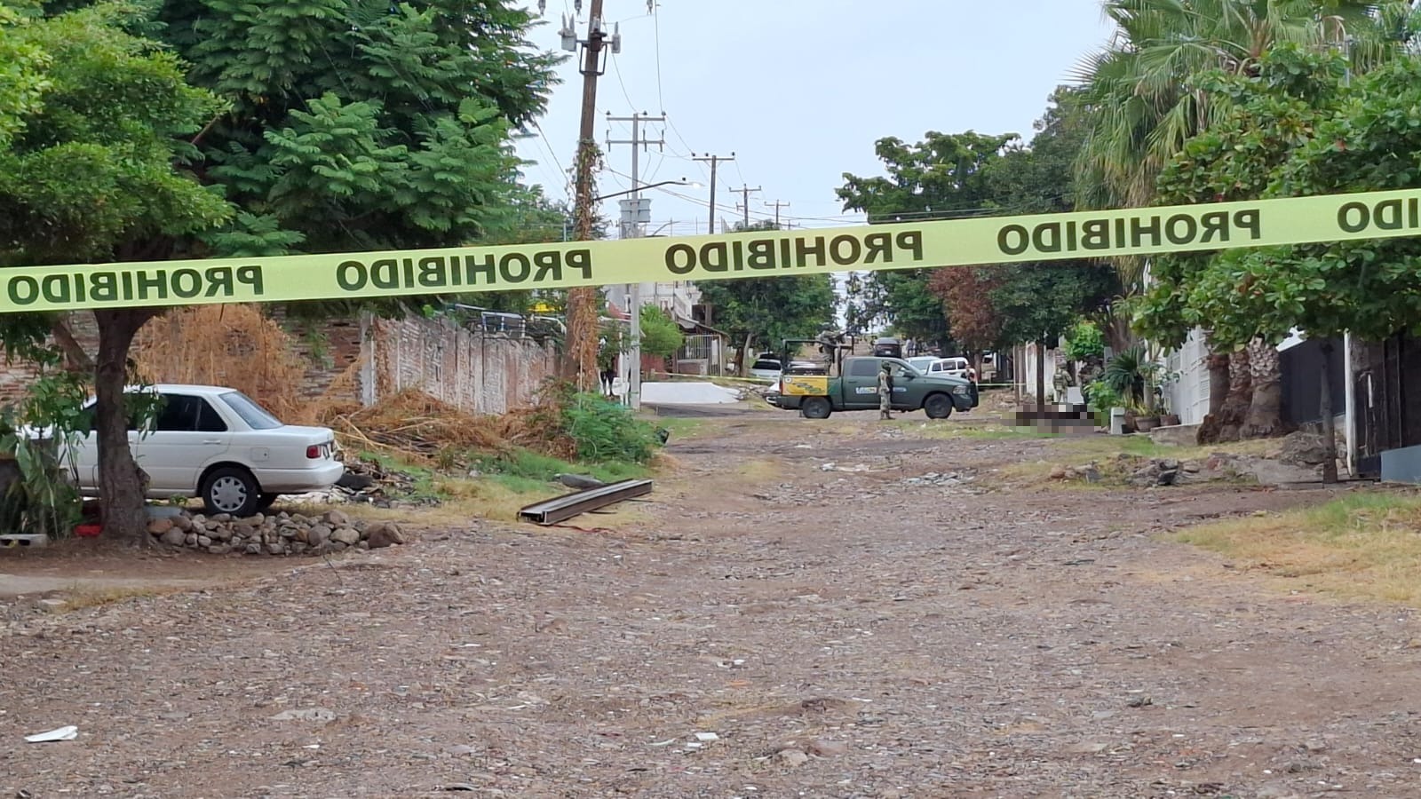 cinta amarrilla delimita calle de terracería donde localizaron a un hombre sin vida
