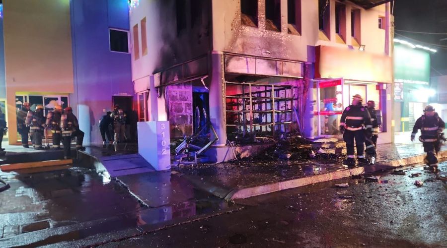 Bomberos desplegados afuera de un establecimiento incendiado