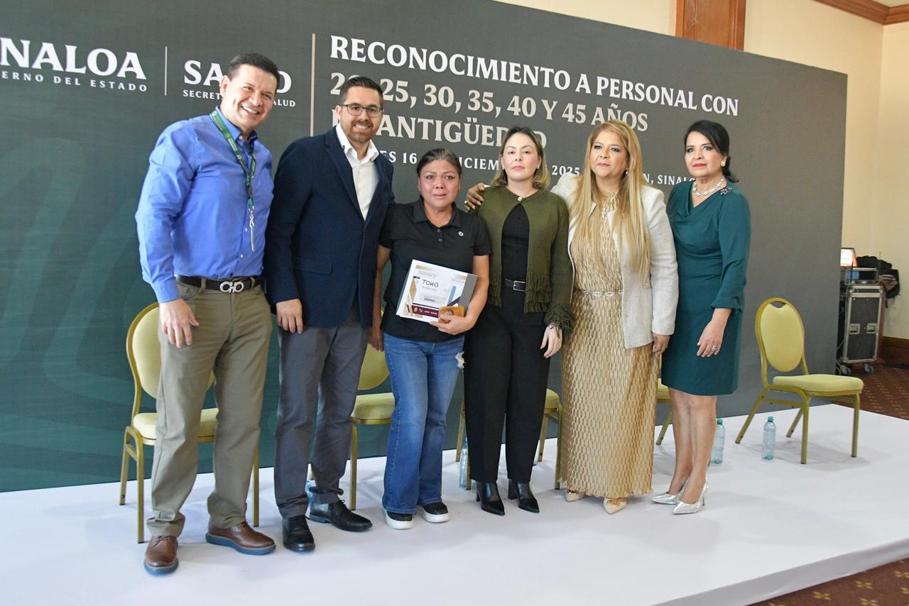 Trabajadora de la Salud junto a funcionarios posando para la foto