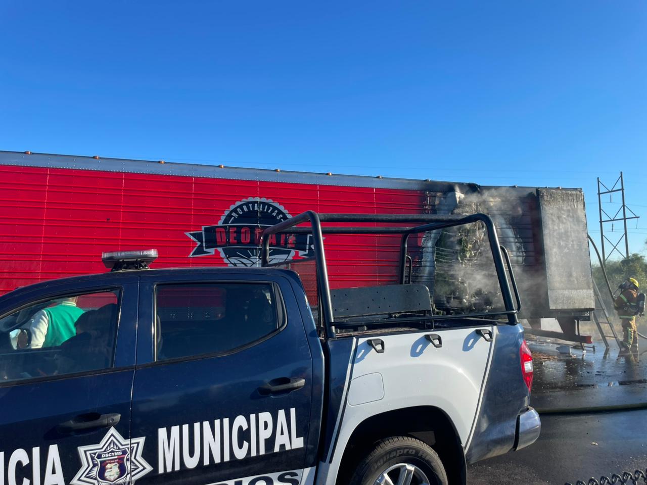 Unidad de la policìa municipal y atrás una unidad de carga color rojo quemada