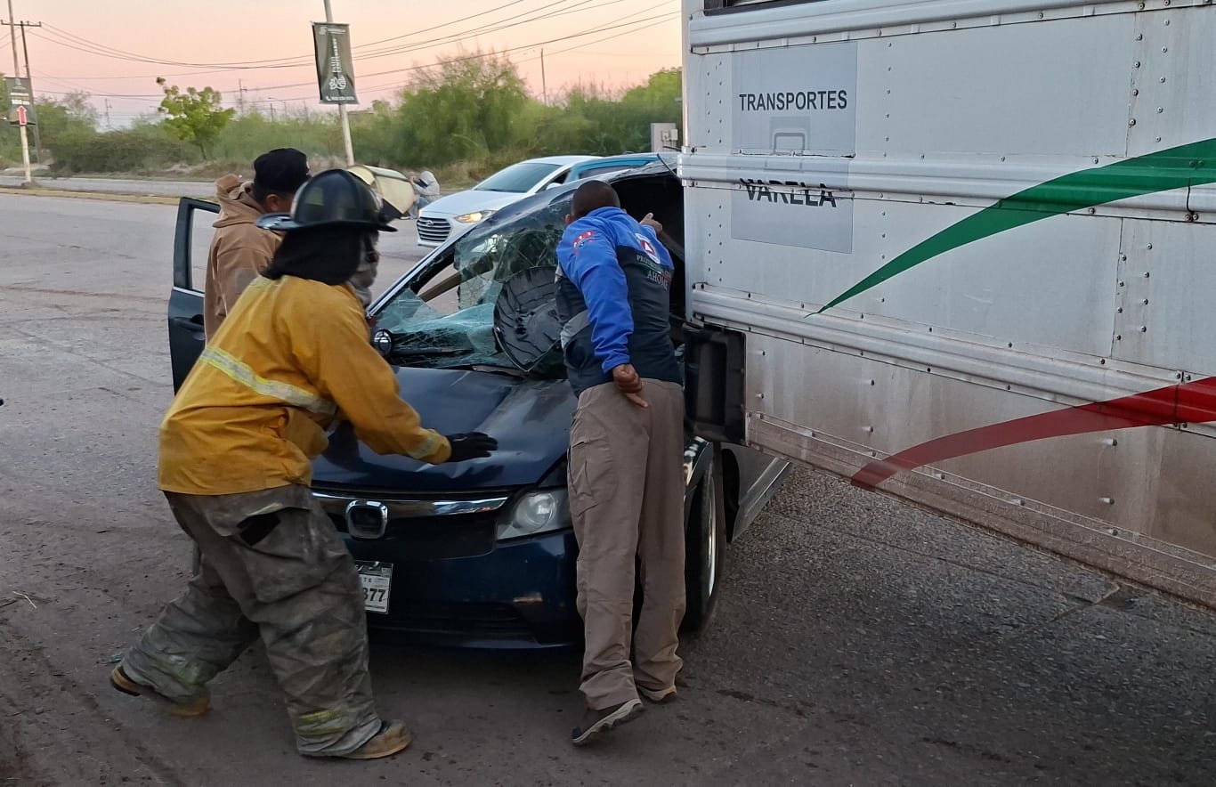 Carro negro chocado con un autobus, elementos de emergencias en el lugar