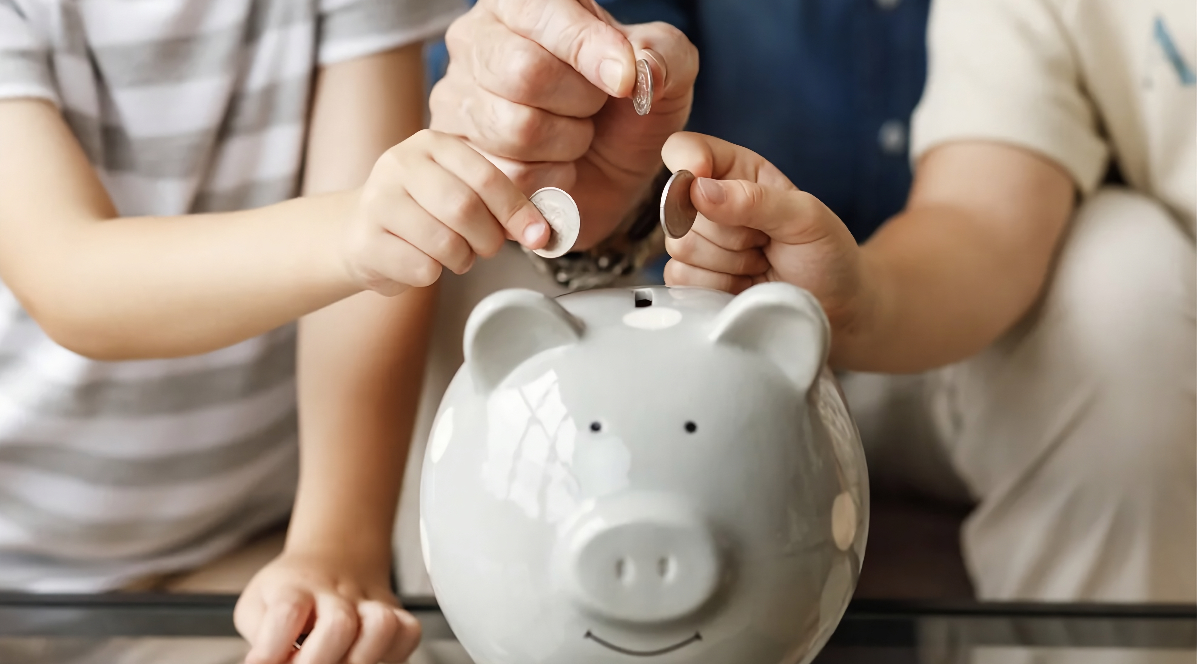 Personas a punto de meter monedas en una alcancía en forma de cochinito