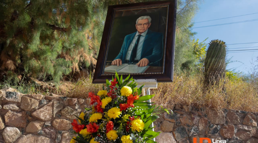 Retrato de Conrado Espinosa en exposición y debajo de el, flores