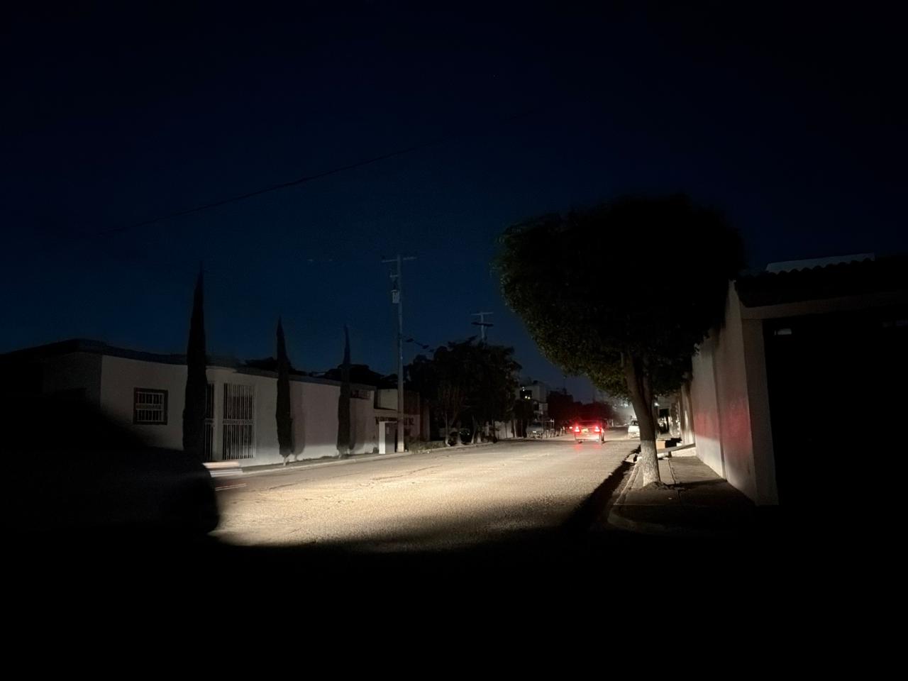 Calle sin luz con un carro pasando