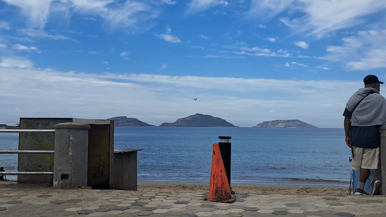 Playa de Mazatlán, un cono que delimita el área y una persona parada en la orilla
