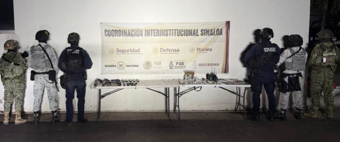 Elementos policiacos junto a una mesa con diferentes objetos y una lona