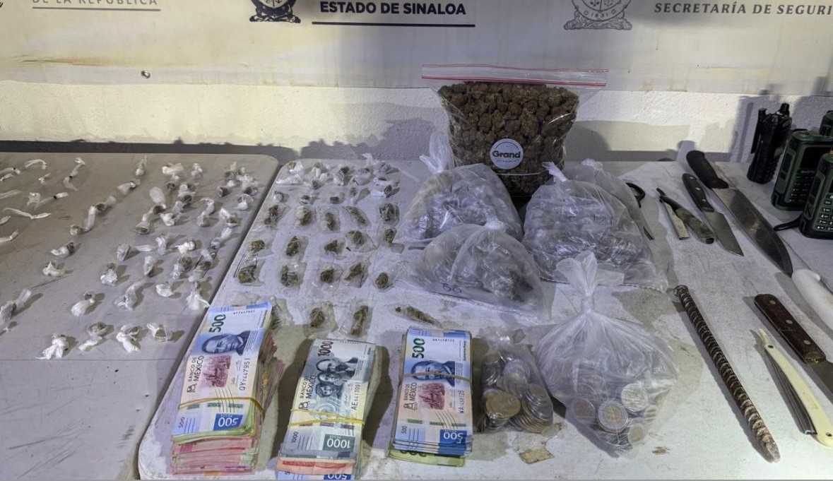 Mesa con dinero, droga, armas blancas y demás objetos