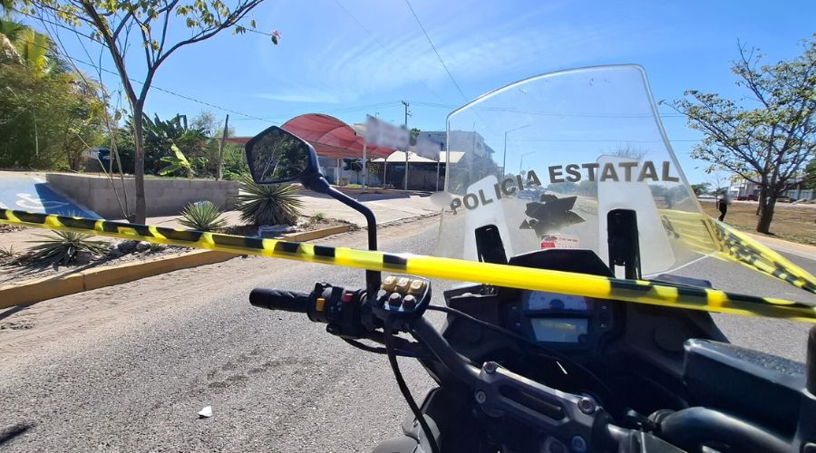 Cinta amarilla de precaución con una motocicleta en una calle