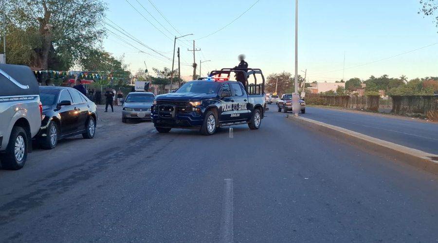 Umidad de la Policía Estatal en Culiacán atravesada en una calle donde hay vehículos estacionados