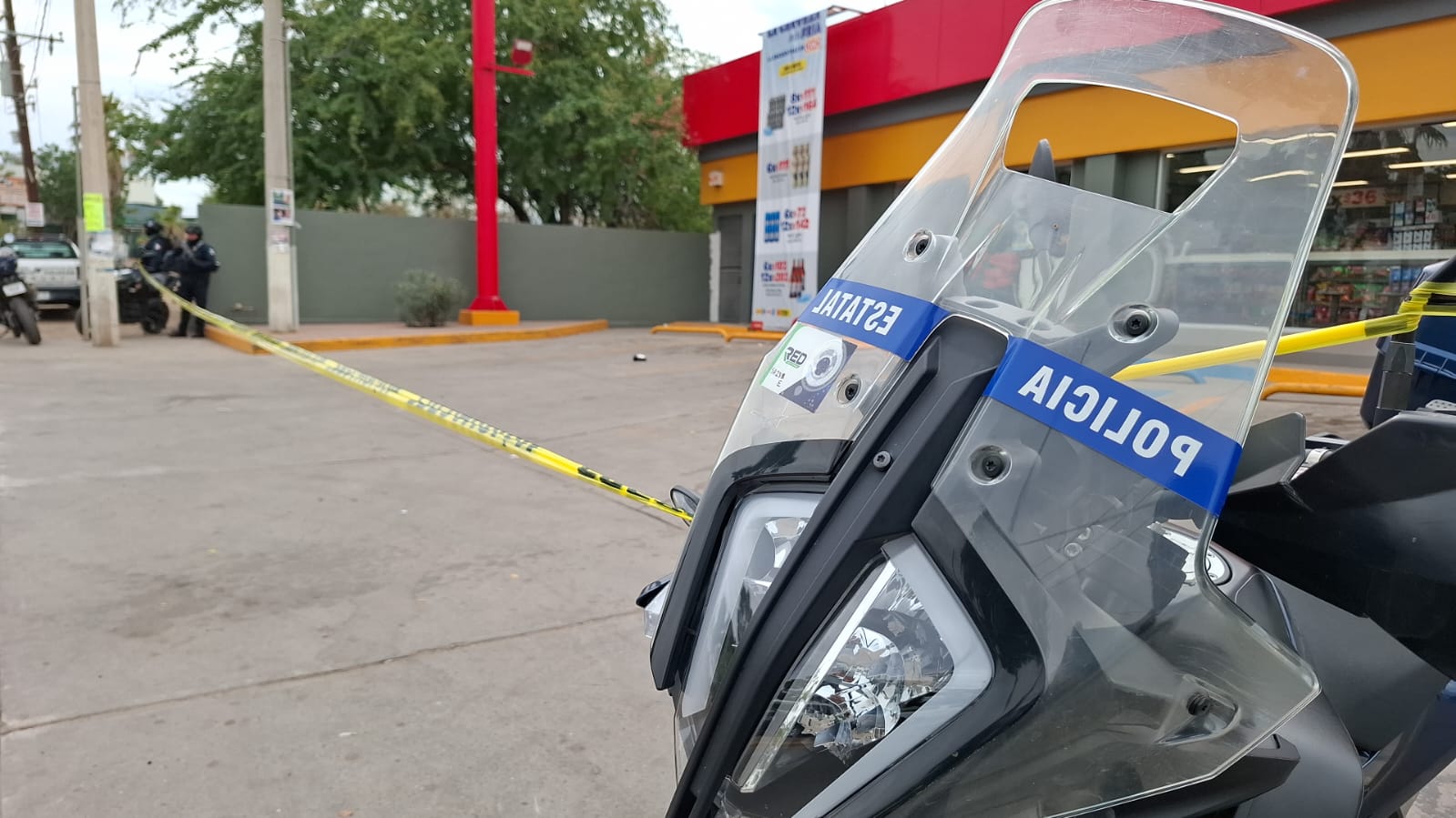 Motocicleta de la policía municipal junto a cinta amarilla de precaución