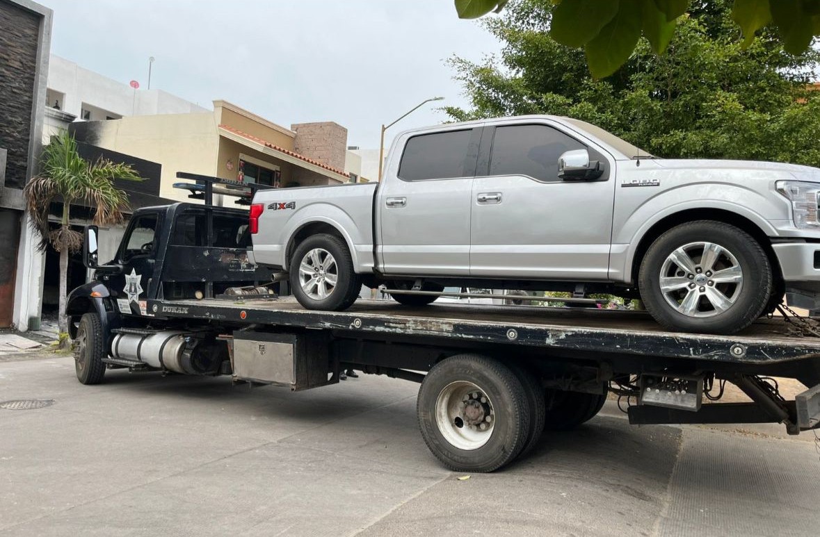 Camioneta gris arriba de una grúa