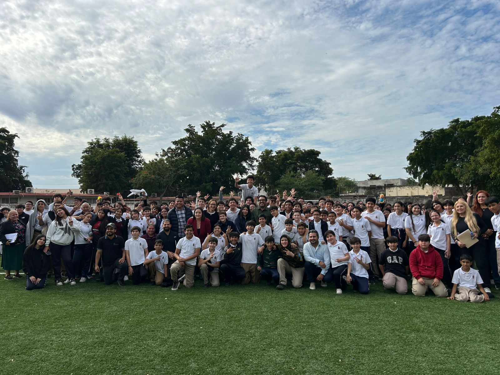 Alumnos, maestros y autoridades municipales en cancha de futbol posando para la foto