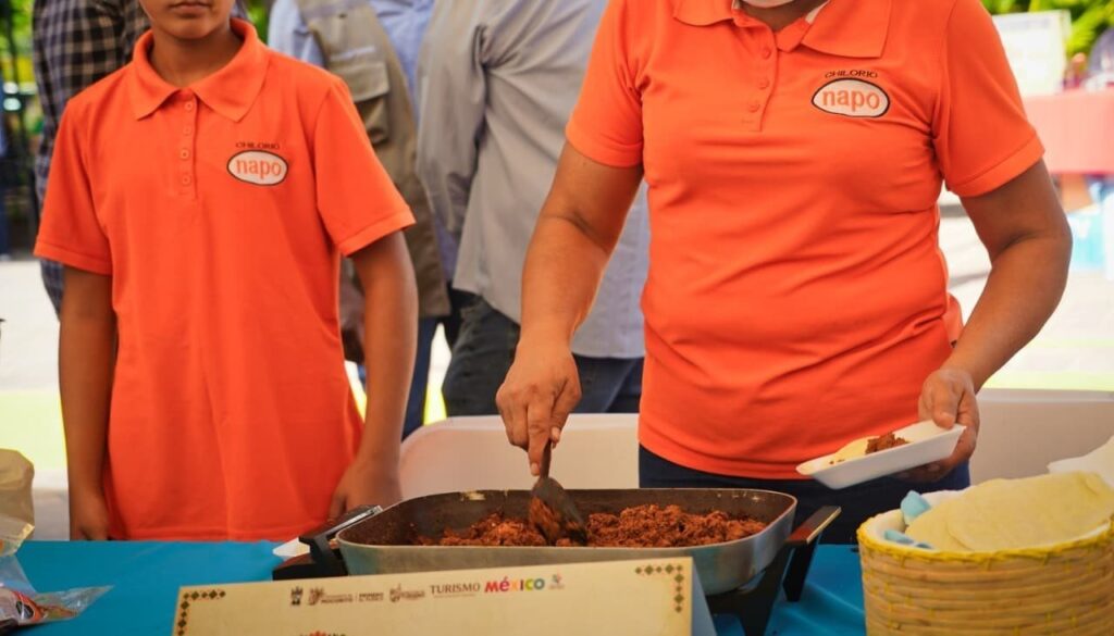Una persona agarrando con una cuchara chilorio de un sarten
