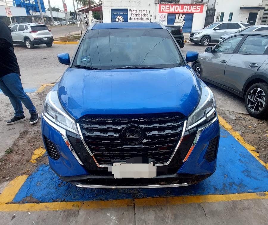 Vagoneta Nissan azul que se impactó contra el laboratorio.