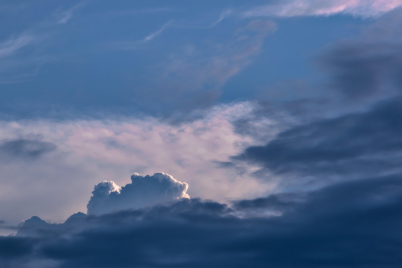 Cielo azul casi cubierto por nubes blancas y en tonos grises
